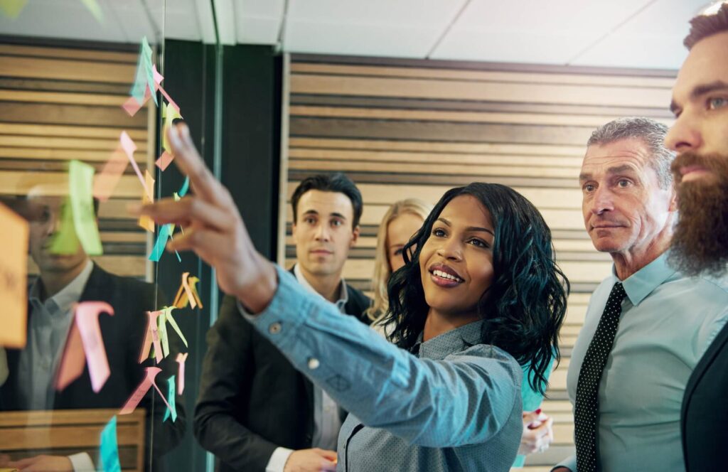 Colleagues work on a project board