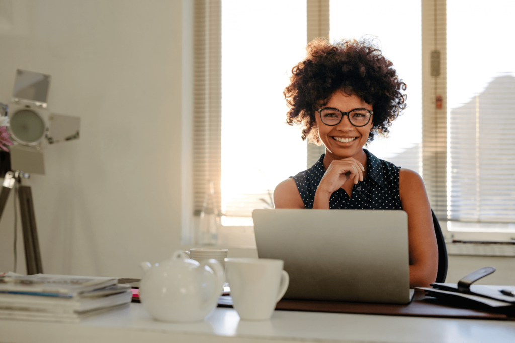 Global Skills-Based Volunteer smiling in front of laptop